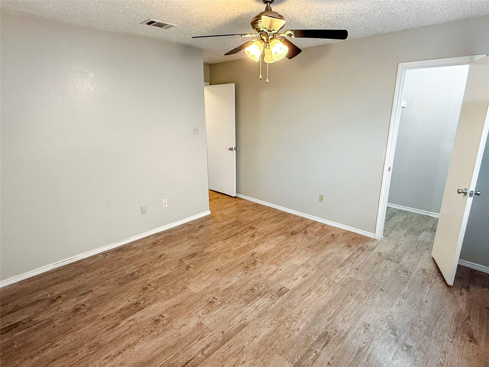 409 Rawhide Loop Round Rock, TX 78681 - Photo 4 of 14 Spacious room featuring wood-finish flooring, light neutral wall tones, and a ceiling fan with integrated lighting
