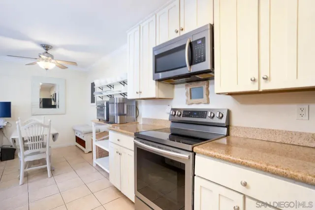 a kitchen with stainless steel appliances granite countertop a stove top oven a sink dishwasher and white cabinets