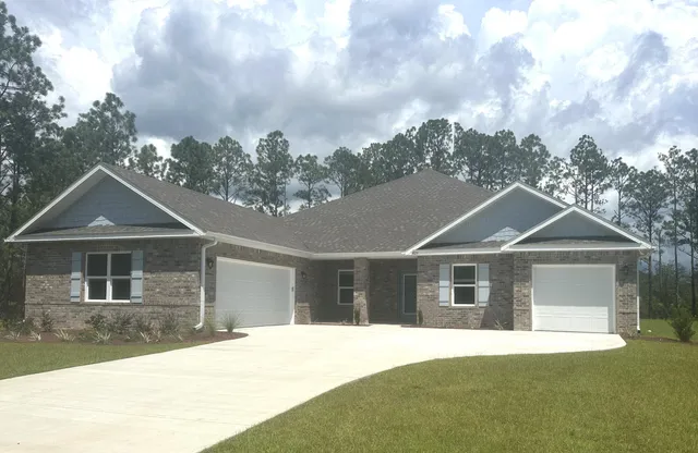 a front view of a house with yard and green space