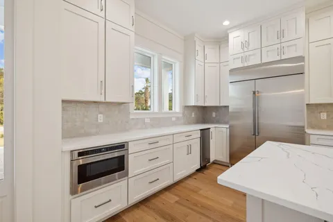 a kitchen with granite countertop white cabinets and white appliances