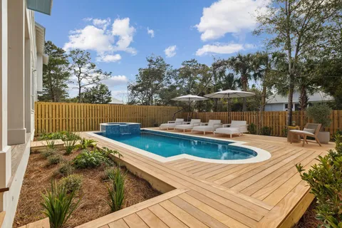 a view of a swimming pool with a patio and a yard