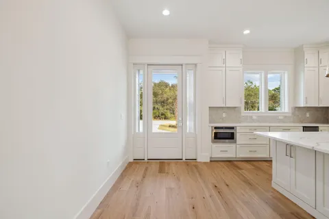 a view of a kitchen with wooden floor and electronic appliances