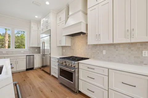 a kitchen with stainless steel appliances white cabinets and a stove a sink