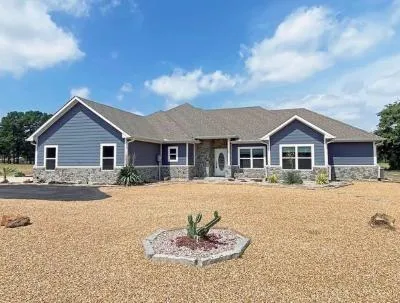 a front view of a house with a yard covered in snow
