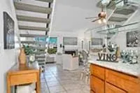 a living room with couches and kitchen view with wooden floor