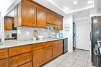 a kitchen with stainless steel appliances granite countertop a sink and a refrigerator