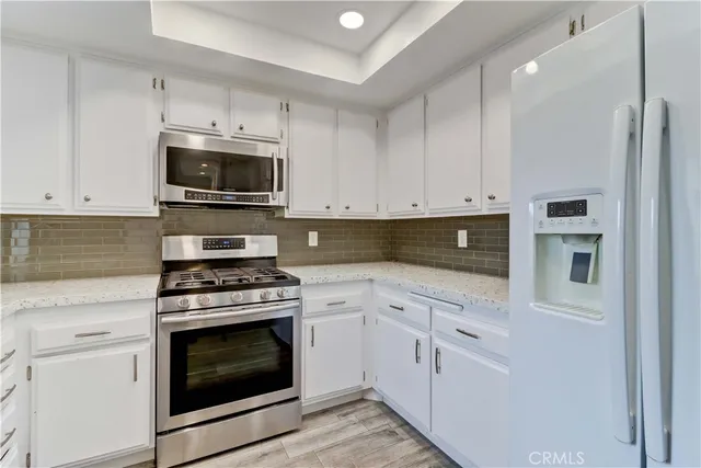 a kitchen with granite countertop a stove top oven and cabinets