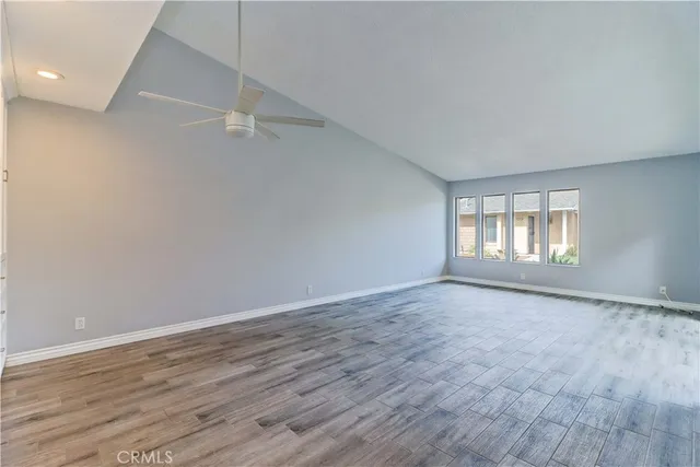 a view of an empty room with wooden floor and door