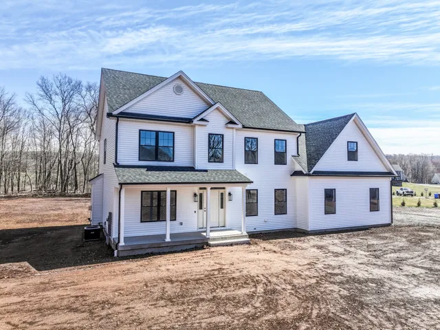 a front view of a house with a yard covered in snow