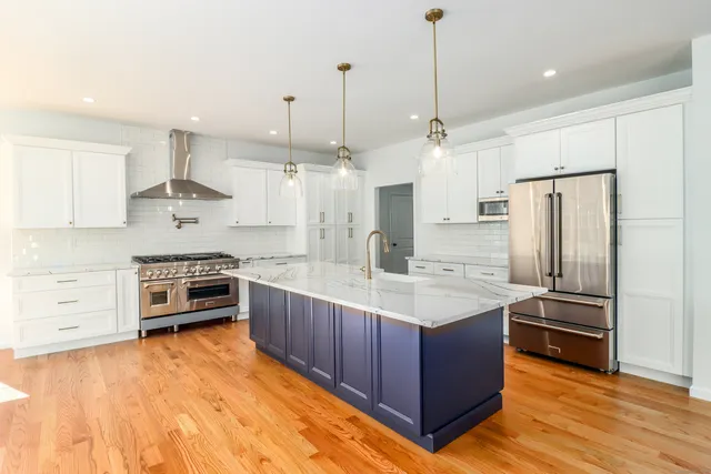 a kitchen with granite countertop a stove a sink and a wooden floors