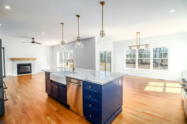 a kitchen with stainless steel appliances granite countertop a sink a stove and a wooden floors