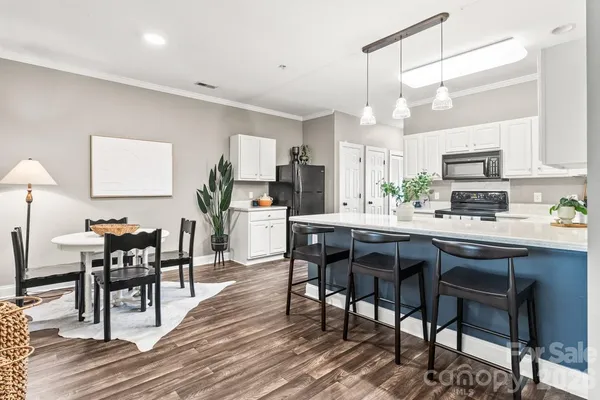 a kitchen with a dining table chairs and white cabinets
