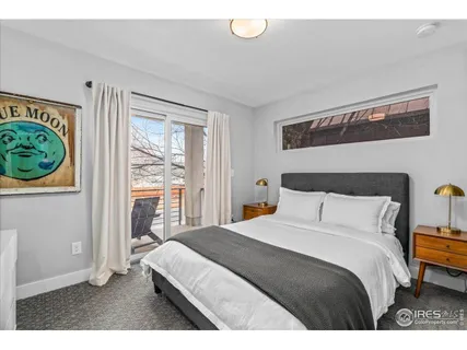 a bedroom with a bed a mirror and a window