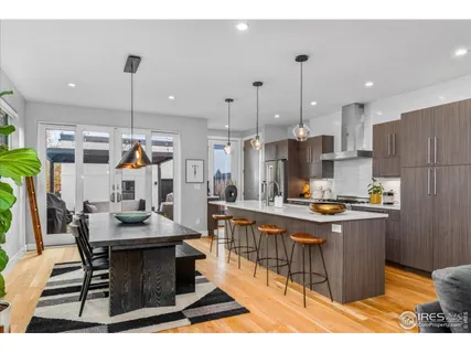 a kitchen with stainless steel appliances kitchen island granite countertop a table chairs and a refrigerator