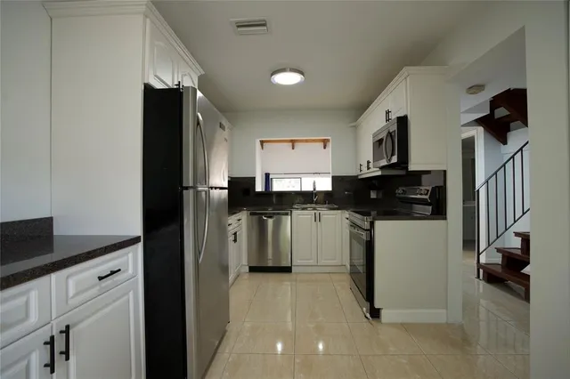 a kitchen with a refrigerator and a stove top oven