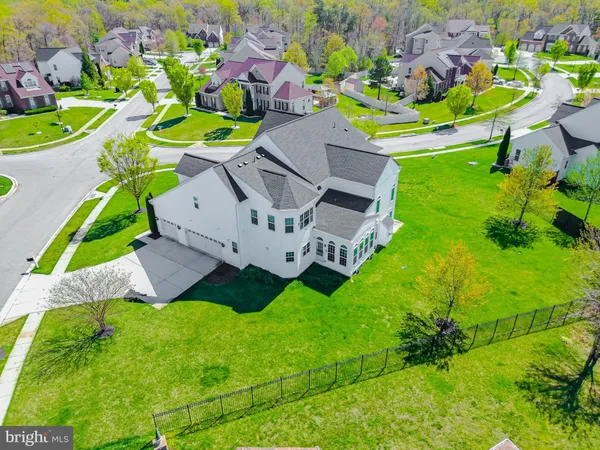 a view of a house with a big yard plants and large trees