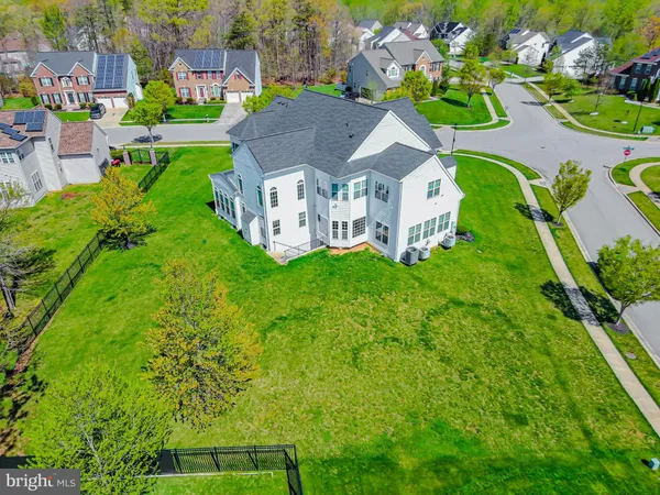 a aerial view of a house with a big yard potted plants and large tree