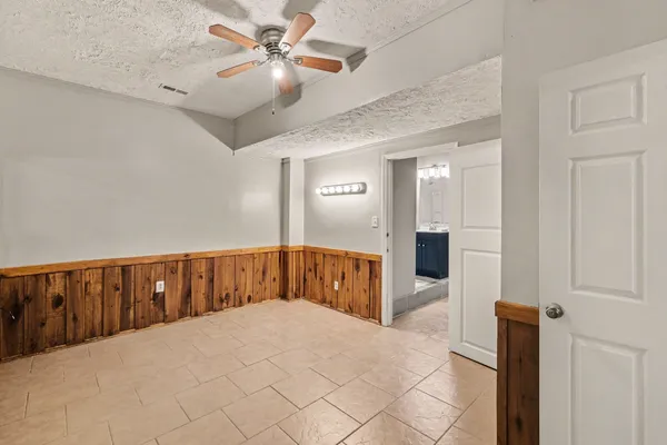 a bedroom with a large bed and a chandelier