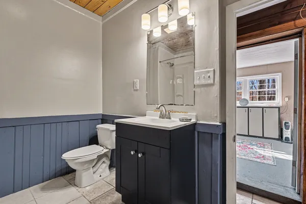 a bathroom with a toilet a sink and mirror