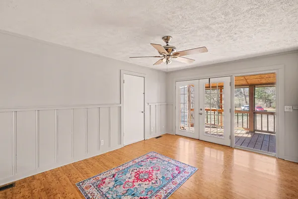 a view of an empty room with a window and wooden floor
