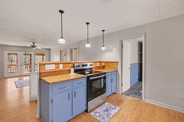 a kitchen with stainless steel appliances granite countertop a sink a stove and a wooden floors