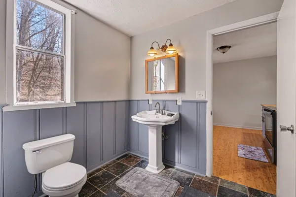 a bathroom with a toilet sink and mirror