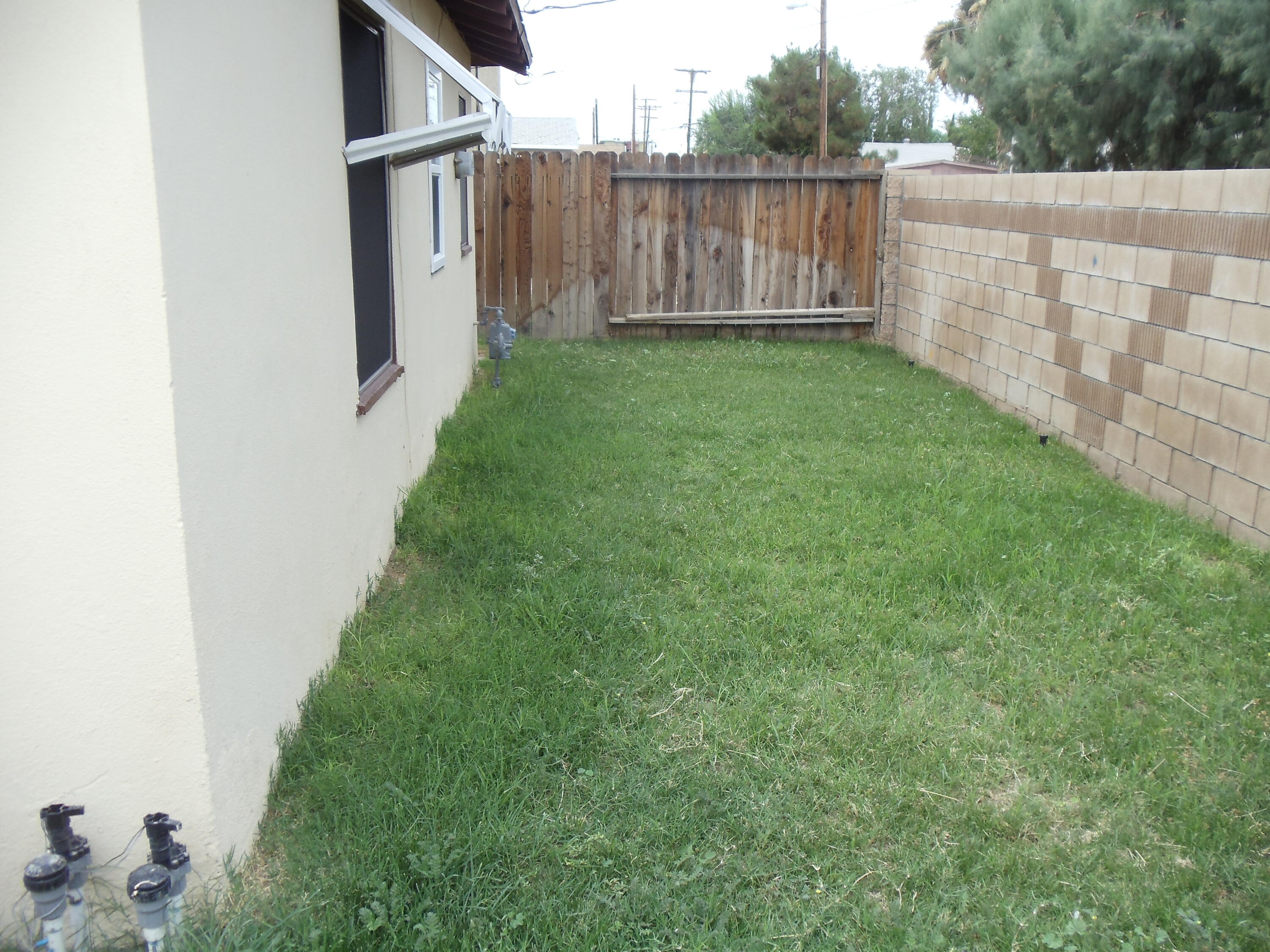 45153 Date Avenue Lancaster, CA 93534 - Photo 7 of 22 a view of a backyard with wooden fence