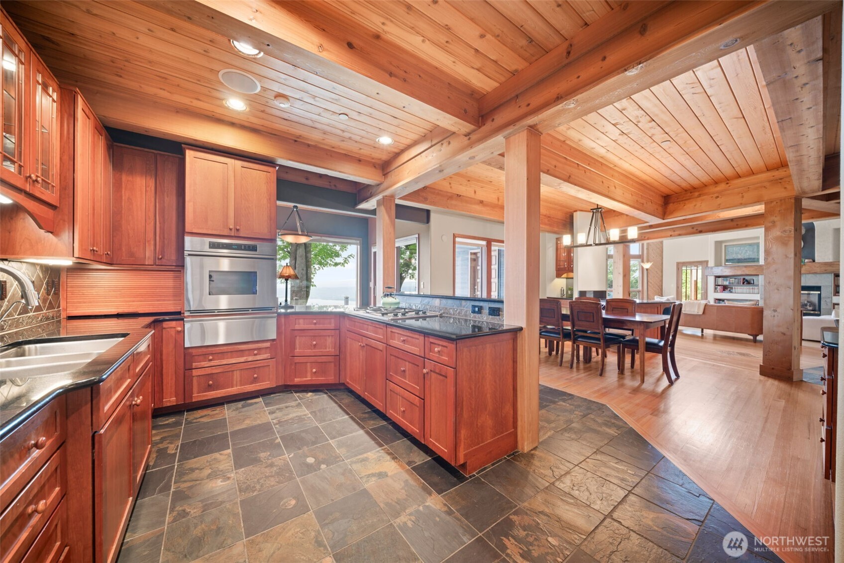 813 Varsity Road Kalama, WA 98625 - Photo 12 of 40 a kitchen with stainless steel appliances granite countertop a stove a sink a dining table and chairs with wooden floor