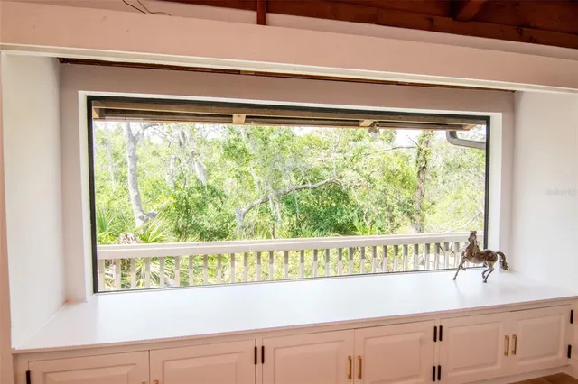 a living room with furniture chandelier and a large window