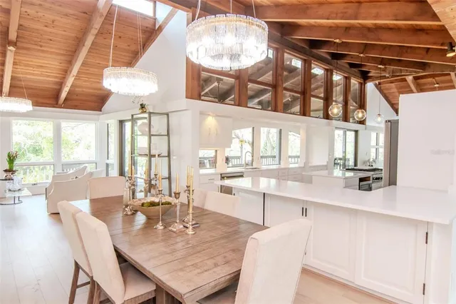 a dining room with furniture a chandelier and wooden floor