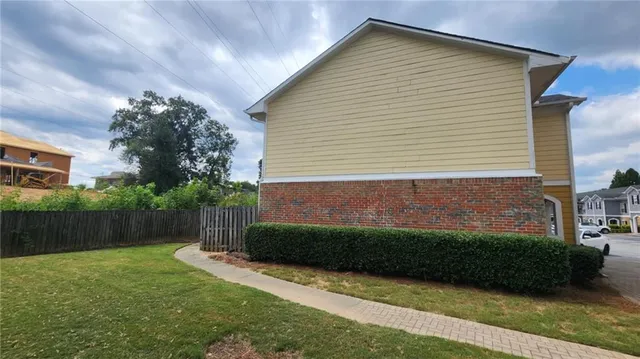 a view of backyard with potted plants and wooden fence