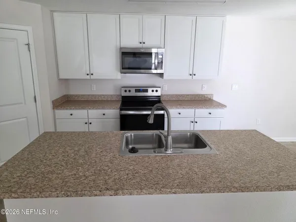 a kitchen with granite countertop a sink and a stove