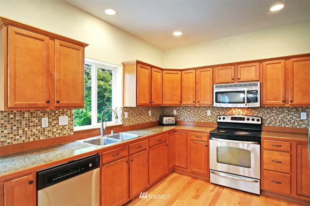 3221 172 Street Southeast Bothell, WA 98012 - Photo 4 of 23 a kitchen with stainless steel appliances a stove sink and cabinets