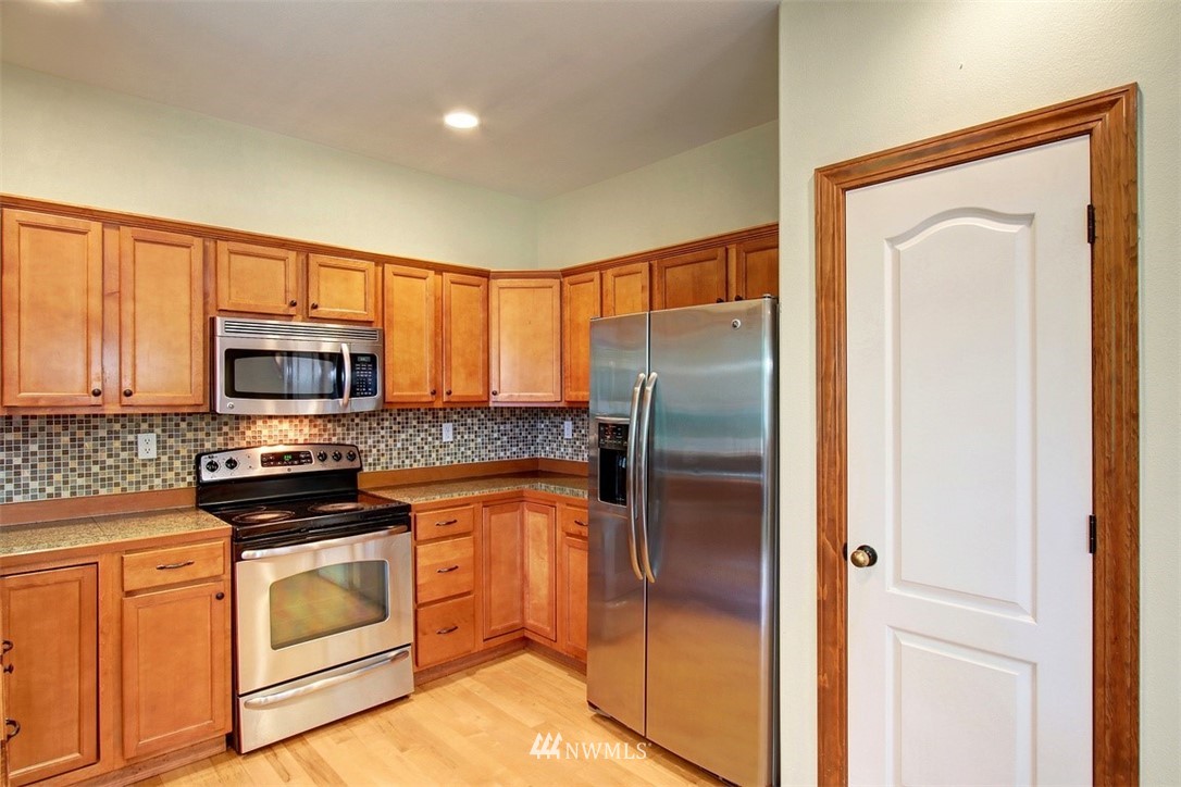 3221 172 Street Southeast Bothell, WA 98012 - Photo 5 of 23 a kitchen with stainless steel appliances granite countertop a refrigerator and a stove top oven