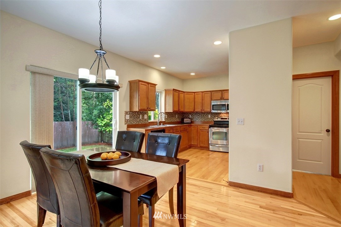 3221 172 Street Southeast Bothell, WA 98012 - Photo 6 of 23 a view of a dining room and livingroom with furniture wooden floor a chandelier