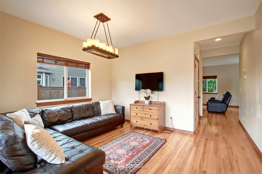 3221 172 Street Southeast Bothell, WA 98012 - Photo 10 of 23 a living room with furniture a flat screen tv and a chandelier