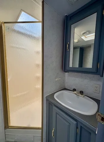 a bathroom with a granite countertop sink toilet and shower