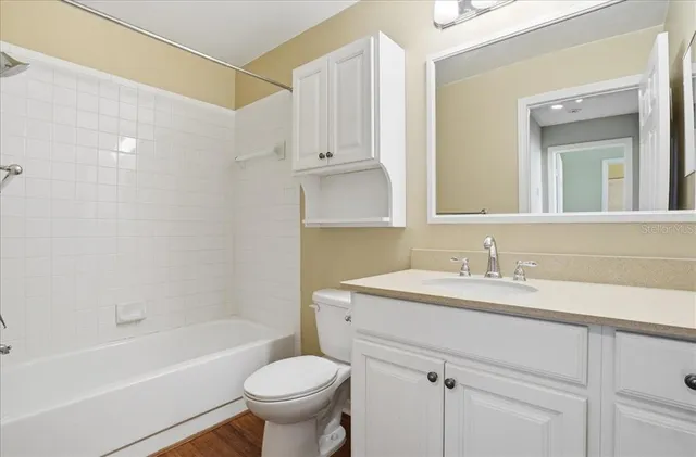 a bathroom with a sink toilet vanity and tub