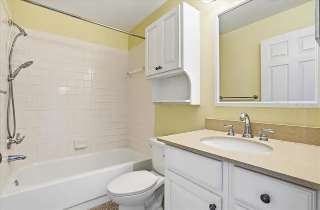 a bathroom with a granite countertop sink a toilet and shower