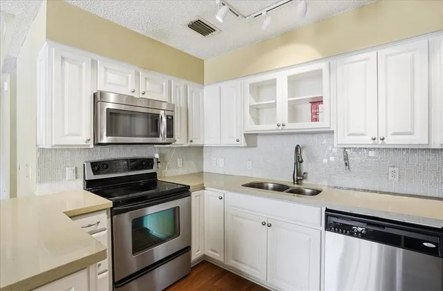 a kitchen with stainless steel appliances a stove microwave and sink