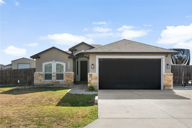 a front view of a house with a yard and garage
