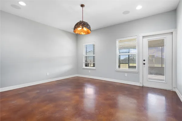 an empty room with windows and ceiling fan