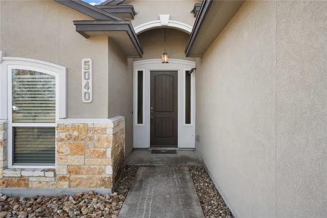 a view of a hallway with wooden floor and a carpet