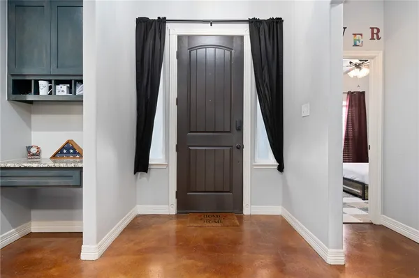 an entryway door with wooden floor