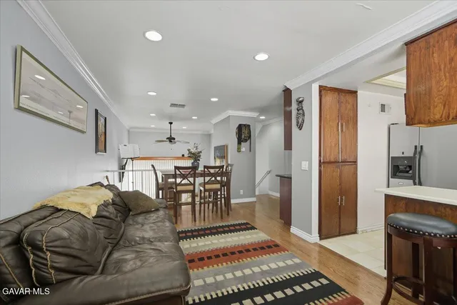 a living room with furniture a kitchen view and a refrigerator