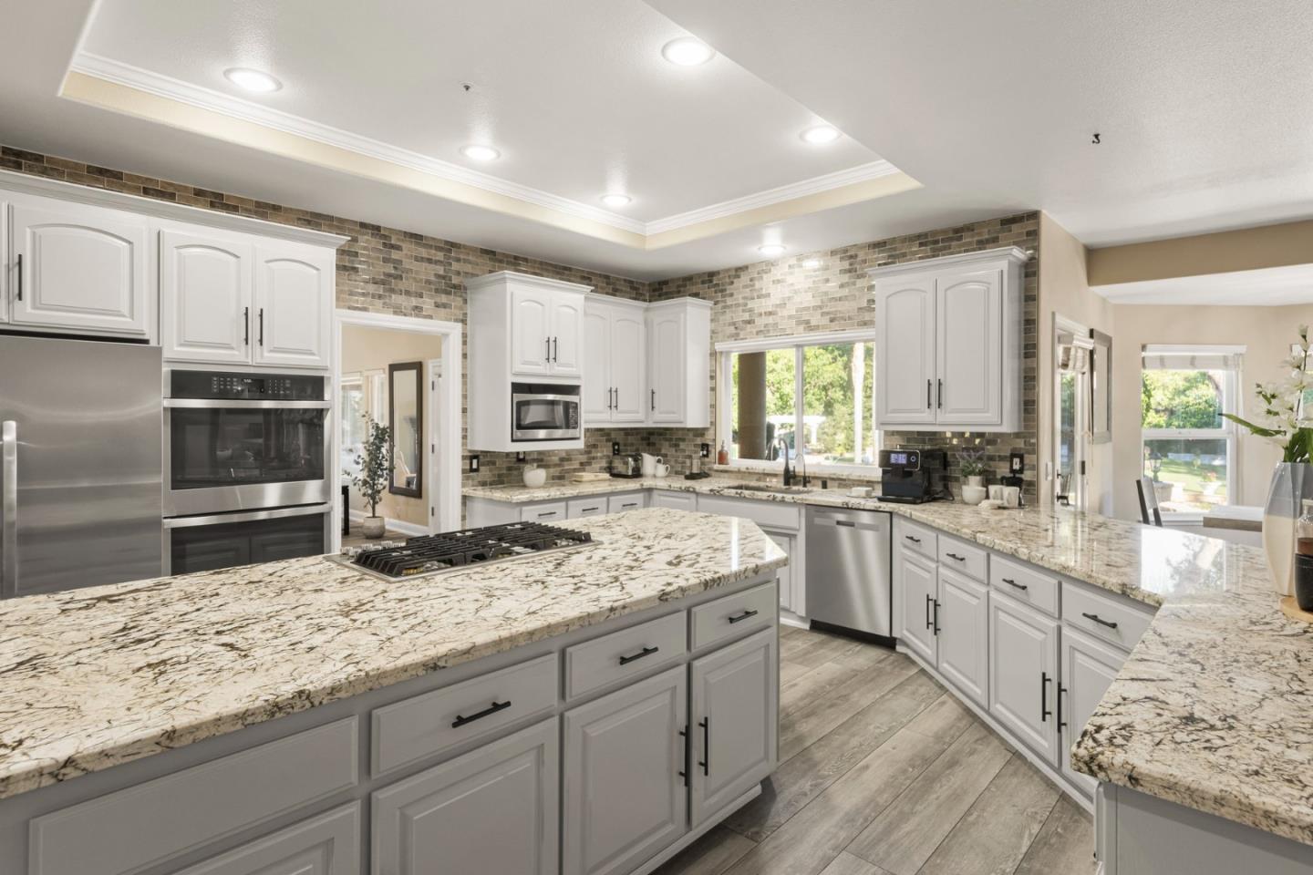 1980 Pear Drive Morgan Hill, CA 95037 - Photo 20 of 100 a kitchen with granite countertop a sink stainless steel appliances and white cabinets