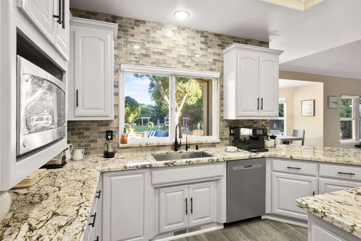 1980 Pear Drive Morgan Hill, CA 95037 - Photo 22 of 100 a kitchen with granite countertop a sink window stainless steel appliances and cabinets