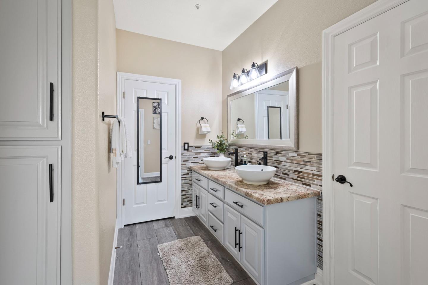 1980 Pear Drive Morgan Hill, CA 95037 - Photo 50 of 100 a bathroom with a granite countertop sink and a mirror