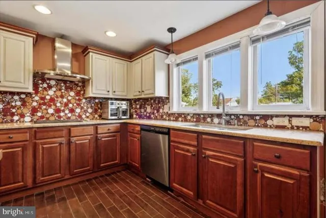 a kitchen with stainless steel appliances granite countertop wooden cabinets a sink and dishwasher with wooden floor