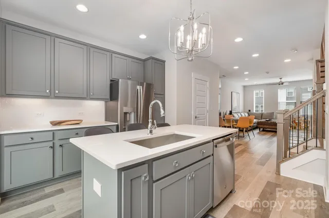 a kitchen that has a lot of cabinets a sink a stove and wooden floors